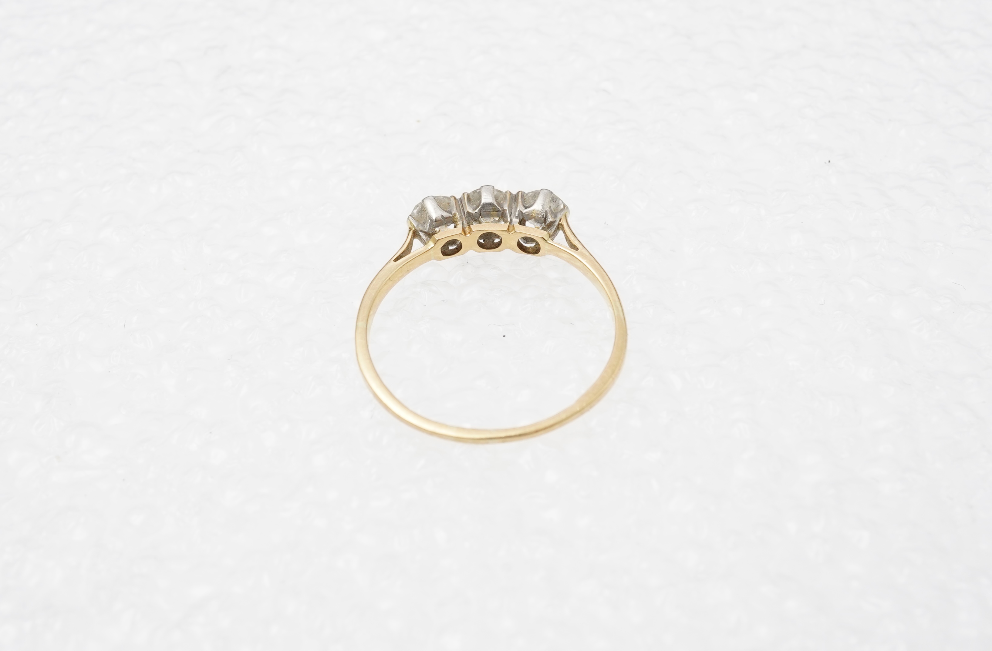 A diamond three-stone ring, set with three circular-cut diamonds totalling approximately 0.50 carats, mounted in gold, size O, stamped 18CT, gross weight approximately 2 grams